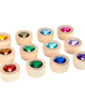 Holz-Funkelsteine Regenbogen 12er Set Die runden in Holz gefassten Funkelsteine ... begeistern die Kinder, denn es sind richtige Schatzsteine. Die Schmucksteine sind stapelbar und eignen sich perfekt für Legespiele, zum Bauen und Spielen, für Weihnachtsdeko, den Einsatz im Jahreszeitenkreis uvm. Ähnlich wie Muggelsteine oder Glasnuggets können mit den 12 farbenfrohen Steinen tolle Muster, und Wege gelegt werden. Außerdem werden sie zum Zählen und Sortieren verwendet. Die Holz-Funkelsteine haben Teelicht-Größe und passen daher wunderbar in Teelichthalter. So bringen die Holz-Funkelsteine nach der Kerzenzeit neuen Glanz auf den Tisch und schmücken Blumen-, Stern- oder Herz-Teelichthalter. Die Kombination mit Bauklötzen und Regenbogen-Material ist eine beliebte Anwendung in der Bauecke. Auf Filzteppichen kommen die Schatzsteine besonders gut zur Geltung. Inhalt: 12 runde stapelbare Holzsteine in 12 Farben.